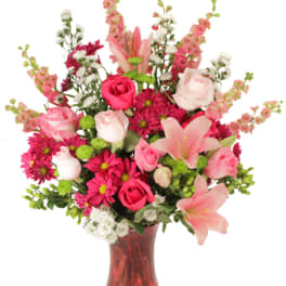 Pink and white mixed flower bouquet in a red glass vase