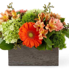 Mixed bouquet in a rectangular wooden box with orange and peach flowers