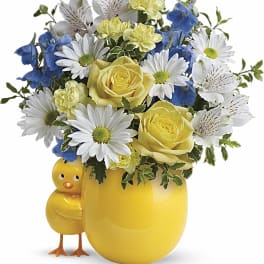 Yellow mug vase with daisies, roses, and blue flowers