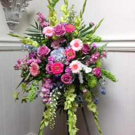 Tall floral spray with pink and purple blooms on an easel