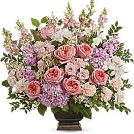 Pink roses and lavender flowers arranged in a dark vase