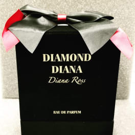 Black perfume box with a large ribbon bow and pink accents