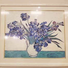 Framed painting of blue flowers in a white vase