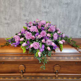 Pink and purple floral casket spray with roses and chrysanthemums