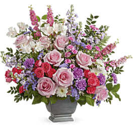 Mixed pink, purple, and white flower arrangement in a gray urn