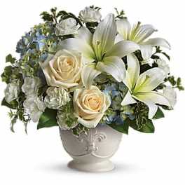 White lilies and cream roses arranged in a decorative vase