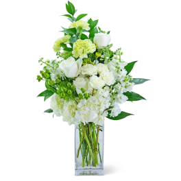 White and pale green floral arrangement in a clear glass vase