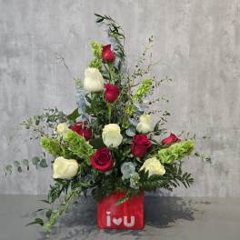 Red and white roses arranged in a red vase with "i love u" text