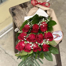 Bouquet of red roses wrapped in brown paper with a red ribbon