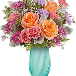 Mixed bouquet of roses, carnations, and daisies in a turquoise vase