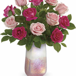 Bouquet of pink and magenta roses in a tall iridescent vase