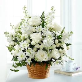 White roses and daisies arranged in a woven basket