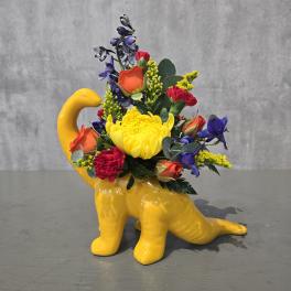 Bright mixed bouquet in a yellow dinosaur-shaped vase