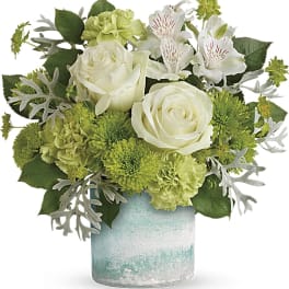 White roses and green flowers in a blue-green vase