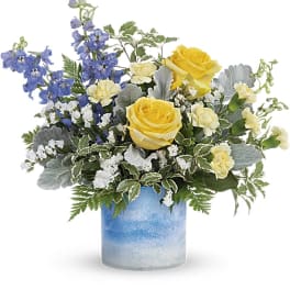 Yellow roses and blue flowers in a blue glass vase