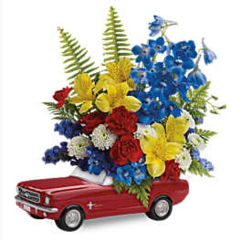 Red toy car topped with a colorful flower arrangement