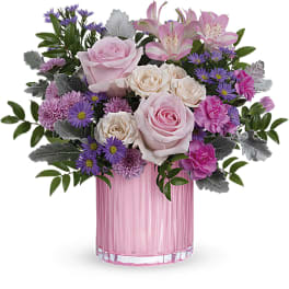 Pink and cream flower arrangement in a pink glass vase