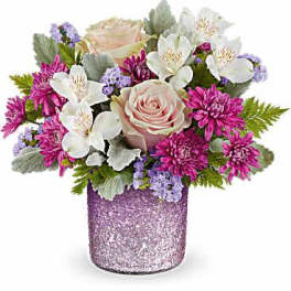 Pink and white flowers arranged in a glittery purple vase