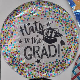 Round graduation balloon with confetti dots and "Hats Off to the Grad!" text