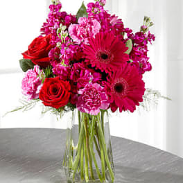 Pink and red mixed bouquet in a clear glass vase