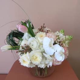 White and blush bouquet with orchids and roses in a glass vase