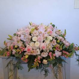 Large pastel floral arrangement with pink and white blooms on a table