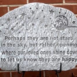 Decorative memorial stone plaque with a starry quote on a brick wall