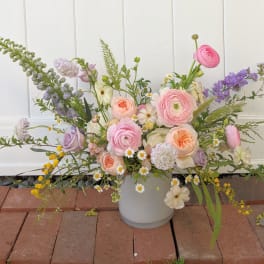 Pastel mixed flower arrangement in a white vase