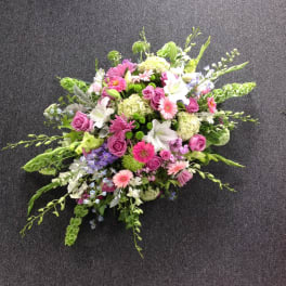 Mixed pink, white, and green floral spray on a dark carpet