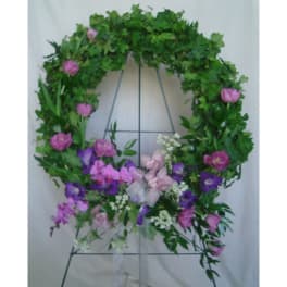 Floral wreath with pink and purple flowers on a metal stand