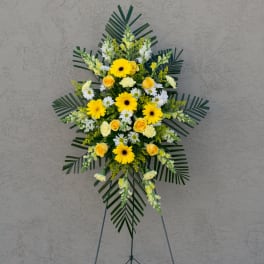 Standing floral spray with yellow and white flowers on an easel
