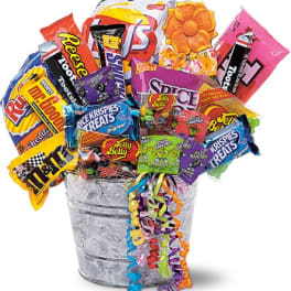 Bucket filled with assorted candy bags and a decorative flower topper