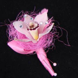 Pink orchid corsage with rhinestone accents on a black background