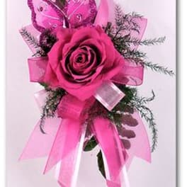 Pink rose corsage with butterfly decoration and ribbon