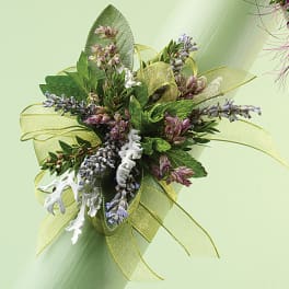 Small floral corsage with purple blossoms and green ribbon