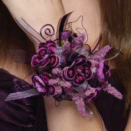 Purple floral corsage with ribbon on a wrist