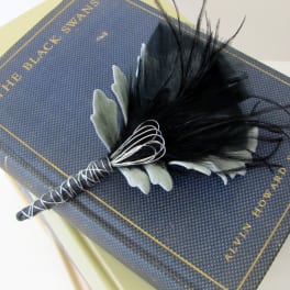 Black feather boutonniere on a boxed item