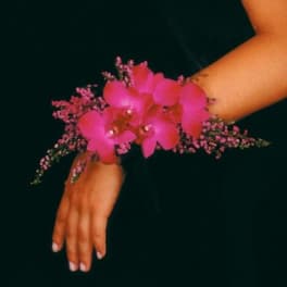 Pink orchid wrist corsage on a person's wrist