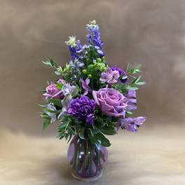 Purple floral arrangement in a glass vase