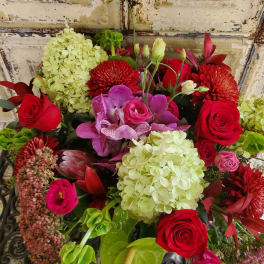 Bouquet of red roses, pink orchids, and pale hydrangeas