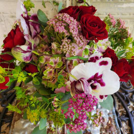 Bouquet of red roses and white-purple orchids with pink filler flowers