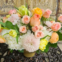 Pastel bouquet of roses, tulips, and chrysanthemums in a low vase