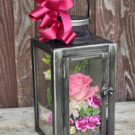 Black lantern with pink flowers and a magenta ribbon bow