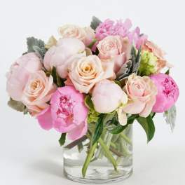 Pink and blush bouquet of roses and peonies in a clear glass vase