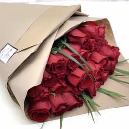 Bouquet of red roses wrapped in brown paper