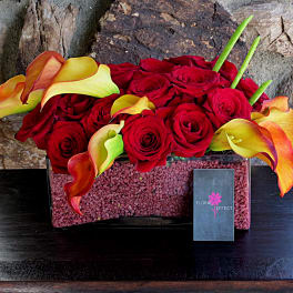 Red roses and orange-yellow calla lilies in a rectangular vase