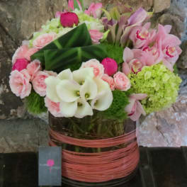 Pink and white floral arrangement in a wrapped vase