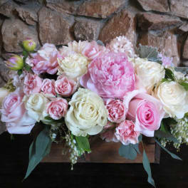 Pink and white rose arrangement in a wooden box