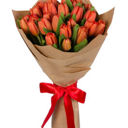 Bouquet of orange tulips wrapped in brown paper with a red ribbon
