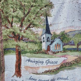 Woven blanket with a church scene and the words "Amazing Grace"